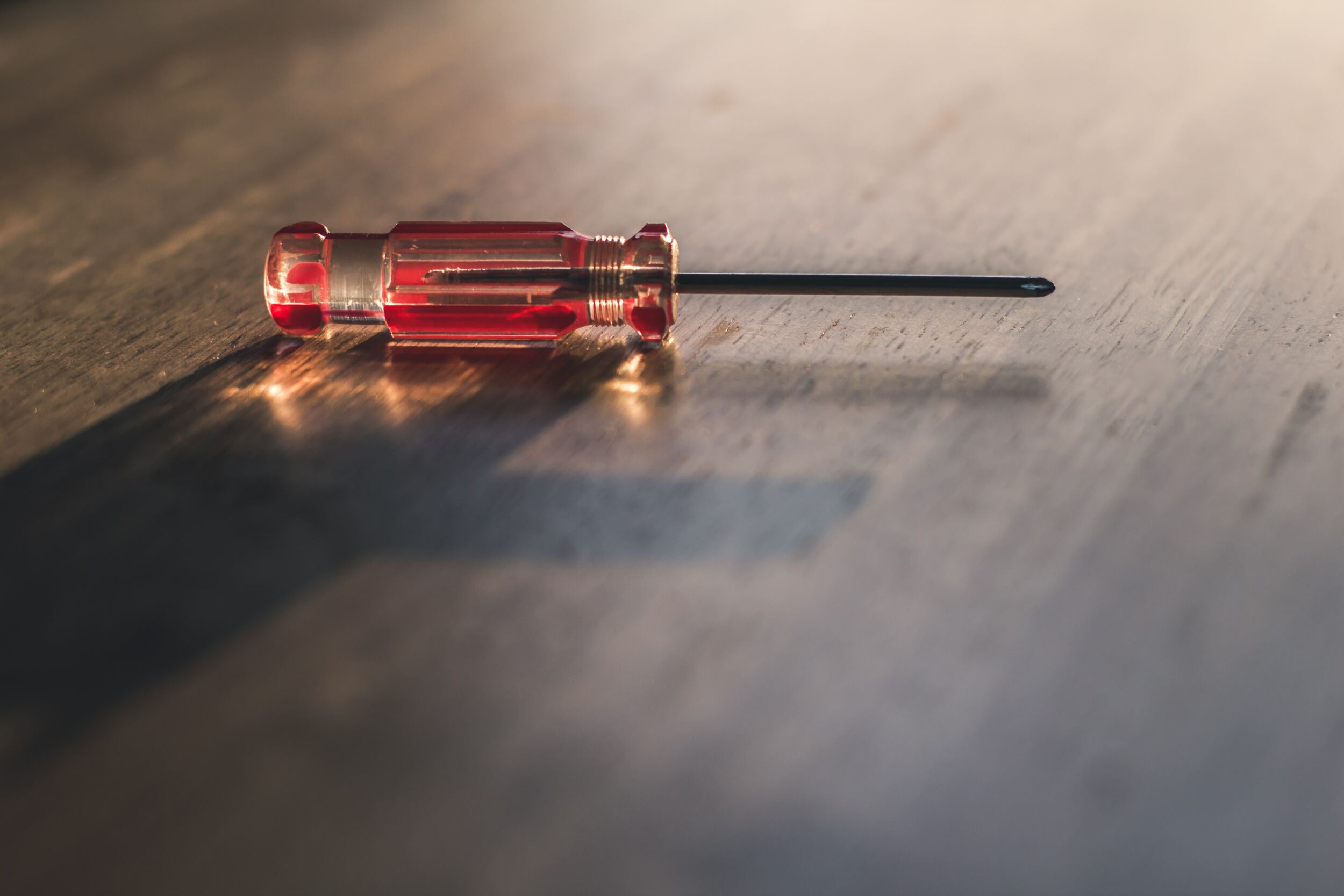 A screwdriver on a wooden surface.