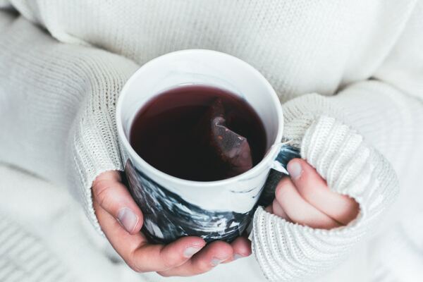 Hands holding a cup of tea.